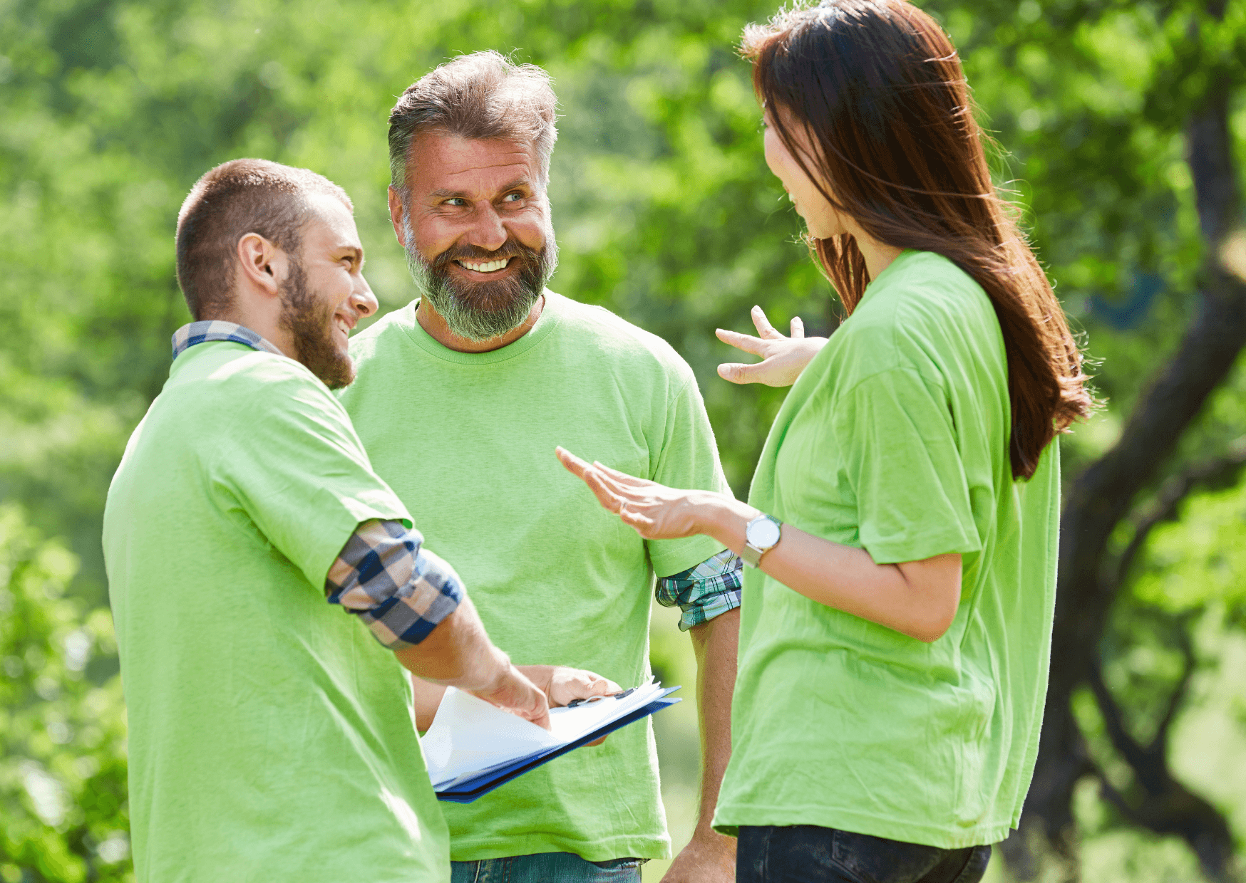 Teamtraining in der Natur mit Oliver Eyth - zwei Männer und eine Frau mit grünem T-Shirt stehen beieinander und besprechen etwas.